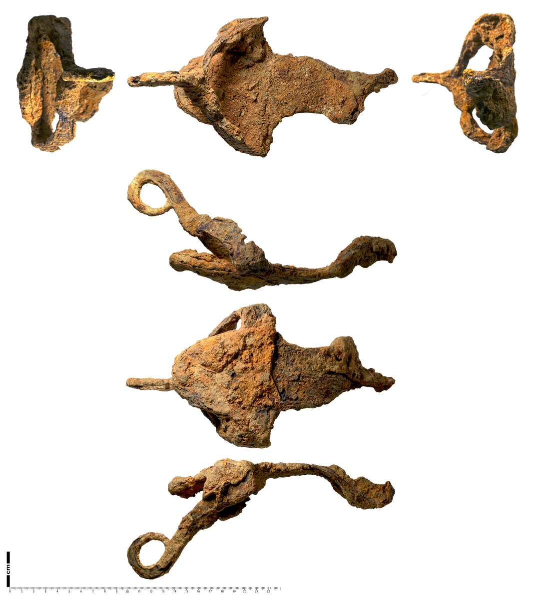A heavily corroded brown iron object from Roman Britain, shaped like a shallow tray the size of a footprint. Its back end curves upward into a hook and two flat wings rise from the sides at the front and curl inward to meet in a loop at the toe.