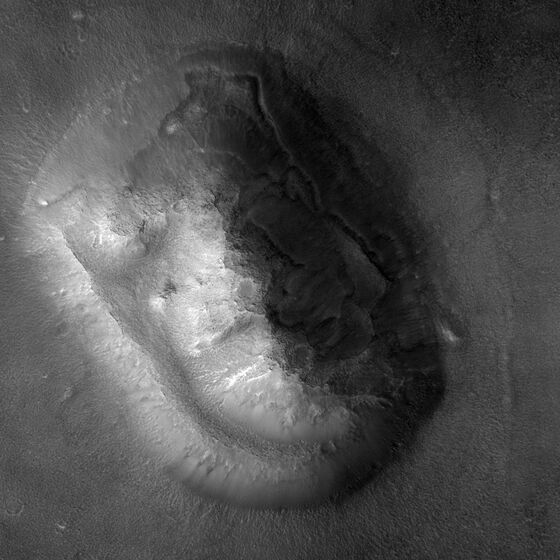 HiRISE image PSP_003234_2210 of the Cydonia mesa, 2007: an eroded, flat-topped hill with rough slopes, lit from the left